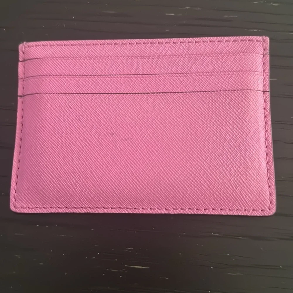 Kate spade bright pink metal logo card holder. 6-pocket; 1 center slot pocket.
